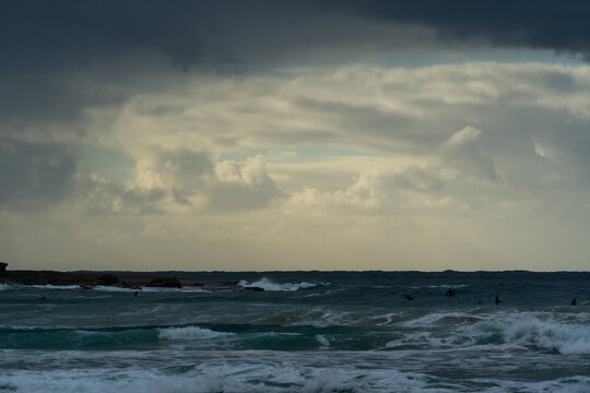 Dark storm clouds gathering over a moody ocean and coastline