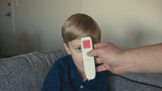 Healthy boy showing thumbs up after temperature check