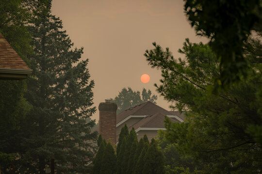Sun dimmed by thick Canadian wildfire smoke haze above a residential neighborhood in Naperville, Illinois