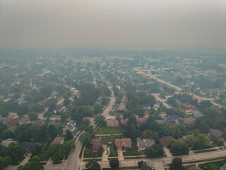Aerial view of a suburban neighborhood in Naperville, Illinois, blanketed by thick haze from Canadian wildfires on July 16, 2026 © Donald