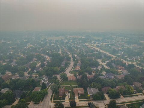 Aerial view of a suburban neighborhood in Naperville, Illinois, blanketed by thick haze from Canadian wildfires on July 16, 2026