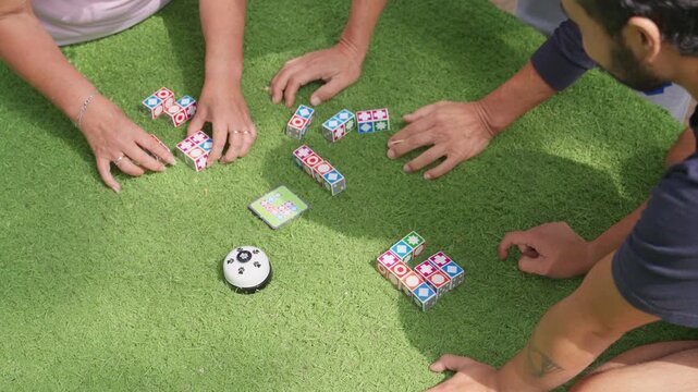 People playing a cognitive board game outdoors on the grass