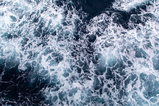 Blue ocean surface with sea foam viewed from above