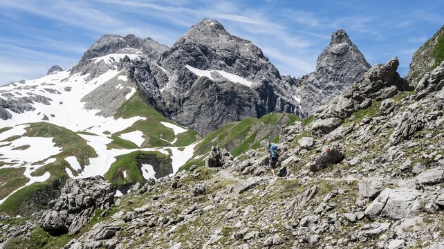 Hiker on hiking trail, in the background old snow fields and rocky peaks of M&auml;delegabel and Trettachspitze, mountain panorama, Heilbronner Weg, Allg&auml;u Alps, Allg&auml;u, Bavaria, Germany