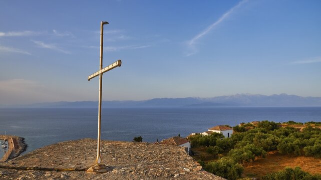 Cross on a hill overlooking the sea and the coastal landscape in the evening light, Koroni, Byzantine fortress, nunnery, Peloponnese, Greece