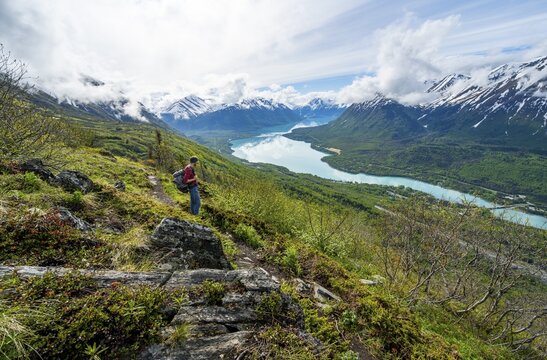 Climbers on a hiking trail, Slaughter Ridge Trail, view of snowy mountains and turquoise lake Kenai Lake, Cooper Landing, Kenai Peninsula, Alaska, USA