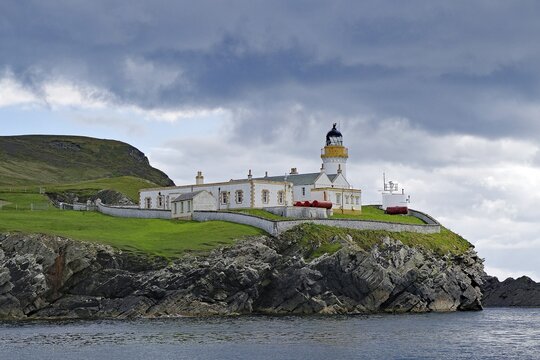 A lighthouse stands on a grassy cliff on a cloudy day, Robert Louis Stevensen, Isle of Noss, Shetland Islands, Scotland, Great Britain
