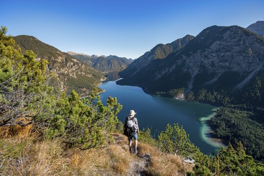 Hiker on hiking trail, view of Plansee, Sch&ouml;nj&ouml;chl in the background, hike to the Schrofennas, Ammergau Alps, Reutte district, Tyrol, Austria