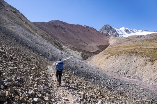Barren high mountains, hiker on the hiking trail to the base camp of Lenin Peak, Osh Province, Kyrgyzstan