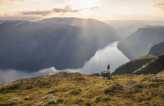 Evening atmosphere, hiker at the top of the mountain Prest, fjord Aurlandsfjord, Aurland, Norway