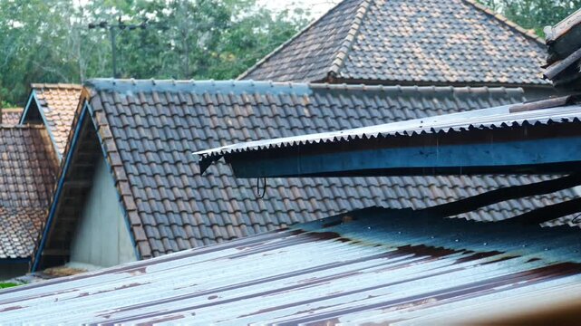 Traditional clay tile and weathered corrugated metal rooftops in a rural Indonesian village
