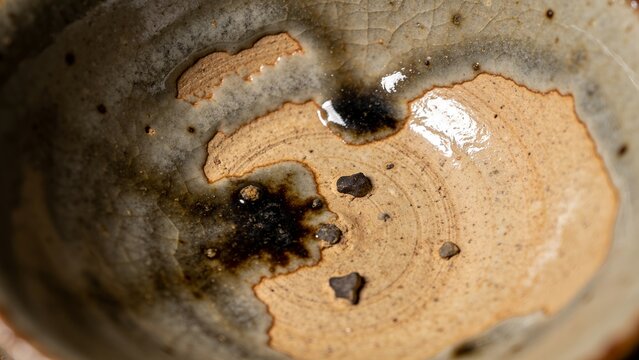 Macro shot of a handmade ceramic tea bowl. Wabi-sabi pottery with rustic organic texture.