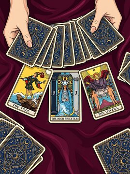 Hands holding tarot cards spread on burgundy velvet cloth