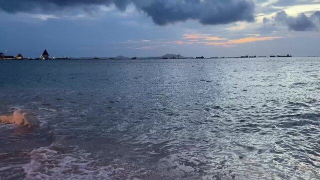 Evening waves rolling onto the beach in Si Racha, Thailand