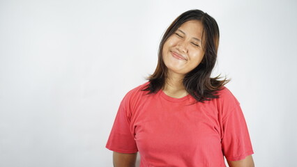 Fototapeta premium Young Asian Woman Smiling Happily with Eyes Closed, Red T-shirt, Studio Portrait