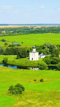 Vertical video. Russia, Bogolyubovo. Drone footage of Church of the Intercession on the Nerl. Orthodox church and a symbol of medieval Russia. Drone footage, Point of interest. Rich colors
