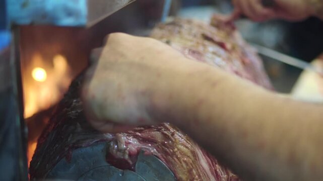Chef Slicing Traditional Doner Kebab Meat on Vertical Rotisserie