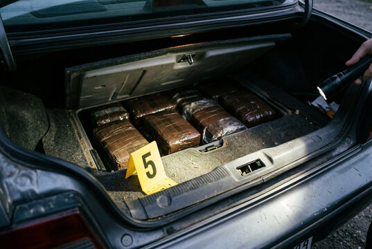 Contraband packages discovered in car trunk at crime scene