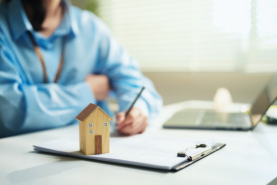 Real estate professional preparing housing transaction documents at a office, property sales negotiation, mortgage application processing, residential market growth, and digital real estate innovation