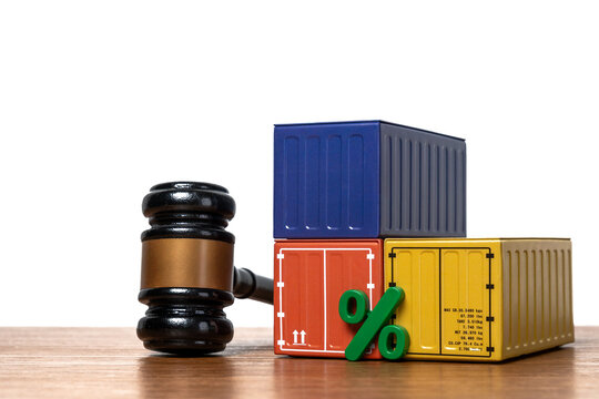 Green percentage sign and shipping containers next to a gavel with copy space. Import tariffs, customs duties, maritime law, trade taxation, and global supply chain regulations concept.