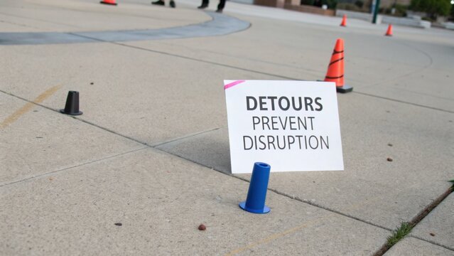 Signage Indicating Detours to Prevent Disruption During Outdoor Event with Traffic Cones and Clean Pavement Surface