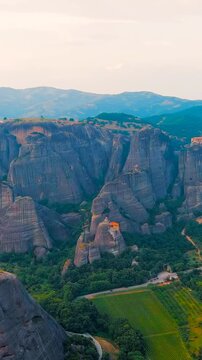 Vertical video. Meteora, Kalabaka, Greece. Meteora - rocks, up to 600 meters high. There are 6 active Greek Orthodox monasteries listed on the UNESCO list. Drone footage, Departure of the camera. Ric