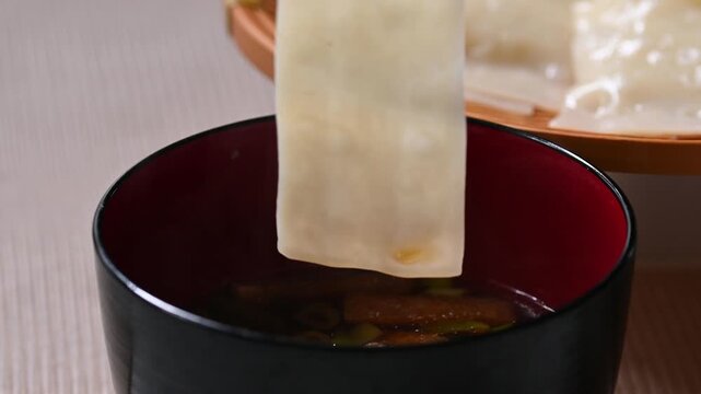 熱々の幅広うどんを持ち上げるクローズアップ