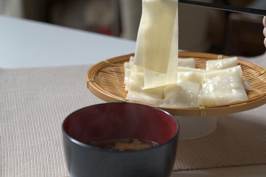 熱々の幅広うどんを持ち上げるクローズアップ