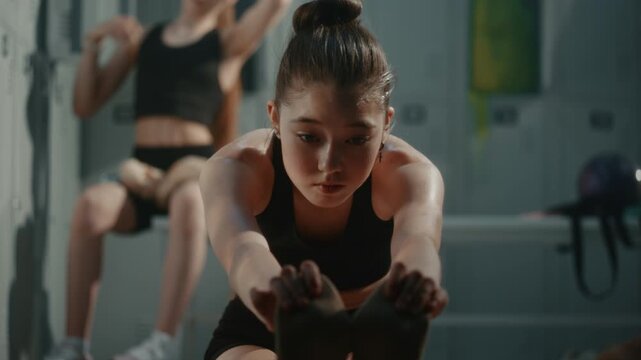 Girl in Athletic Outfit Performs Deep Forward Bend Stretch in Warm Up Session, Improving Hamstring Flexibility, Spinal Mobility. Training Routine, Dedication Required in Competitive Youth Gymnastics.