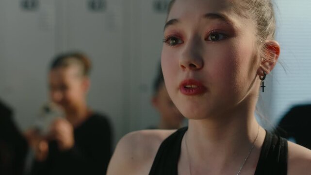 Close up of Young Athlete Harshly Confronts Teammate in Locker Room. Other Girl Using Smartphone Record, Humiliate Her. Toxic Competition, Psychological Stress Among Children in Youth Sports Culture.