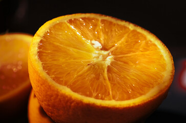 Сlose‑up macro photograph of a fresh orange fruit. The image emphasizes the detailed texture of the peel against a dark, contrasting background. healthy eating, fresh produce, vitamins,  © ElenaEmiliya