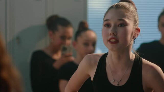 Harsh Conflict Within Children Rhythmic Gymnastics Team. Mean Girl Confronts Classmate in Locker Room, Using Smartphone as Tool Intimidation and Public Shaming. Concept of Bullying, Social Pressure.