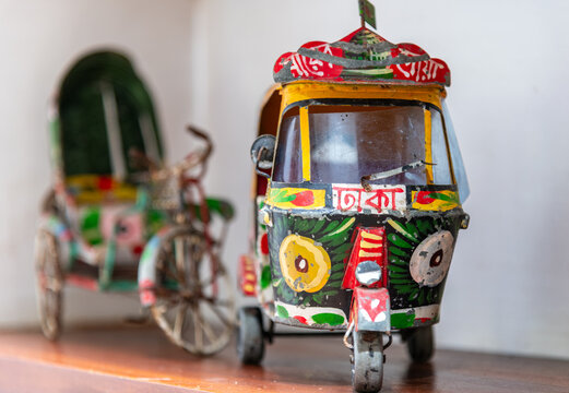 Colorful miniature tuk-tuk and traditional rickshaw souvenirs on a wooden shelf