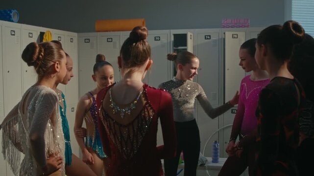 Teenage Female Athletes Standing in Circle, Touching, Examining Each Other Crystal Embroidered Performance Leotards. Girl Pay Compliments Teammates, Creating Supportive Atmosphere Before Competition.
