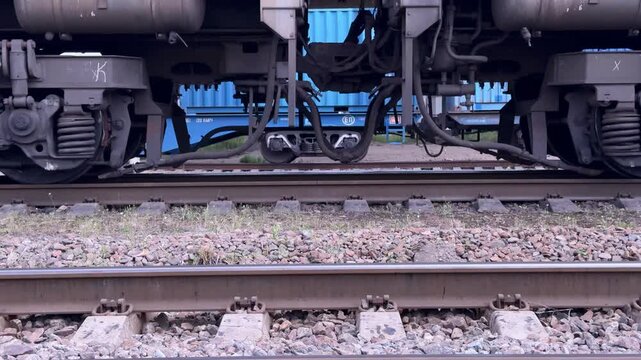 Train wheels rolling along railway tracks, close-up of rail transport in motion, public transportation, industrial engineering, travel infrastructure.