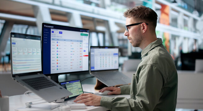Man Using Laptop To Review Supplier Contracts