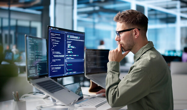 Young Software Engineer Coding On Laptop