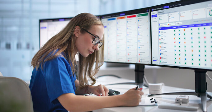 Healthcare Worker Using Credentialing Software On Desktop