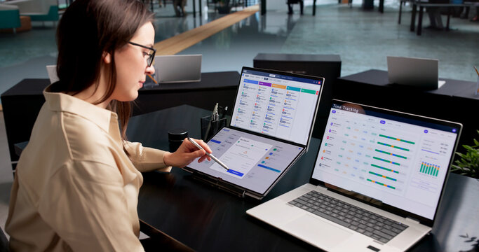 Woman In Office Uses Payroll Software To Track Employee Salary