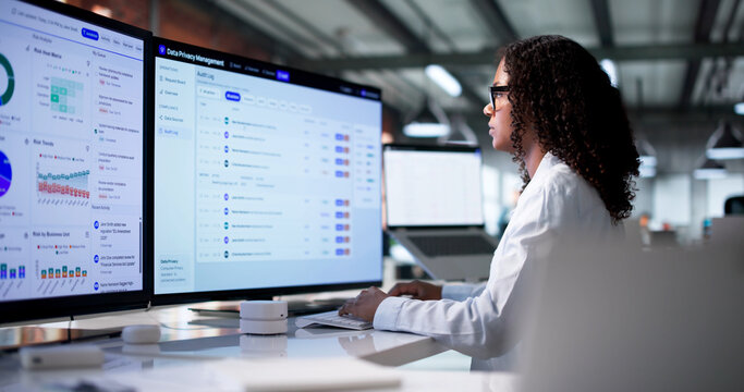 Young Woman Reviews Data Privacy Compliance Dashboard On Computer