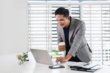 Fototapeta premium Businessman using laptop computer in office. Happy middle aged man, entrepreneur, small business owner working online.