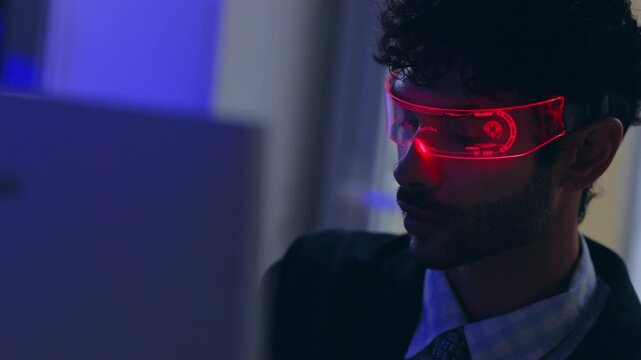 Smart glasses man technology face computer futuristic eyewear office night neon holographic interface portrait professional wearing transparent digital glasses near monitor blue red light