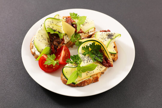 Gourmet bruschetta with zucchini ribbons cheese and sun dried tomatoes