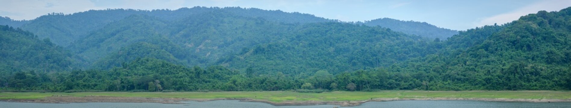 Serene Landscape with Lush Green Mountains and Calm Waters
