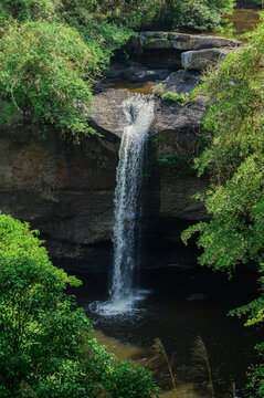 Serene Waterfall Surrounded by Lush Greenery and Rock Formations
