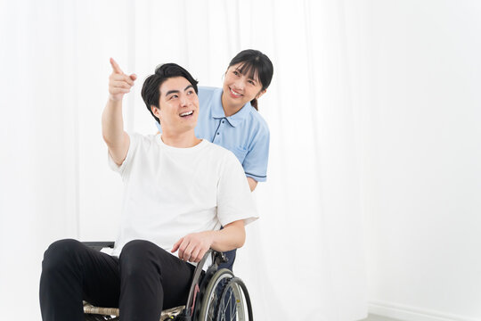 介護スタッフと車椅子の若い男性