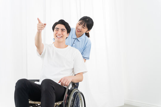 介護スタッフと車椅子の若い男性