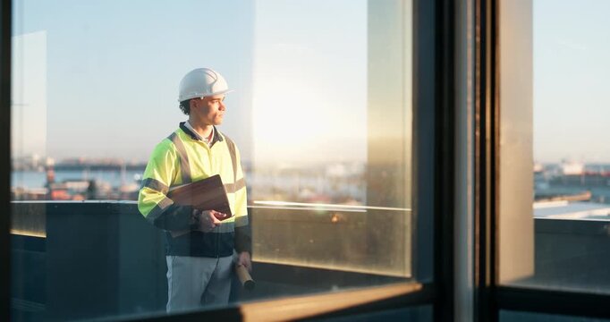 Construction, thinking and man on balcony for building, expansion project and idea for urban planning. Contractor, engineer and person with evaluation for infrastructure, remodeling and development