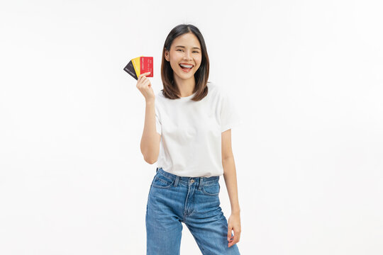 Happy young Asian woman holding credit cards with a confident smile isolated on white studio background.