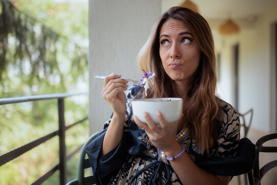 Pretentious Woman Making Funny Face Criticizing Food at Upscale Restaurant. Snobby customer grimaces pretentiously while inspecting a salad bowl inside